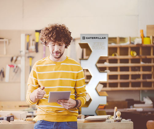 man leaning on table looking at tablet